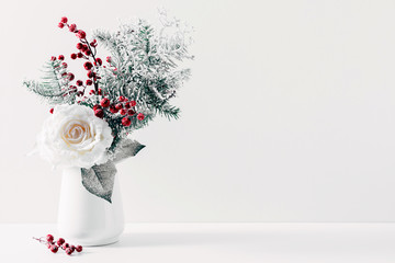 Winter or Christmas composition, decoration, flowers, branches in vase on white background. Christmas home decor, winter concept. Front view, copy space