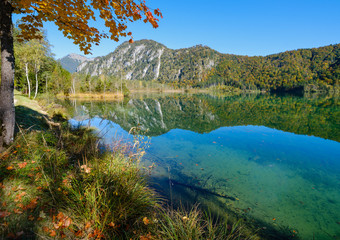Peaceful autumn Alps mountain lake with clear transparent water and reflections. Almsee lake, Upper Austria.