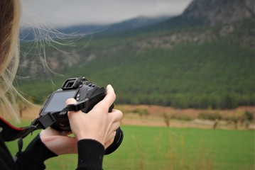 chica revisando una fotografía en el campo