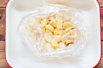Step-by-step preparation of pork ribs with potatoes in the oven, step 3 - putting all the ingredients in a baking dish, top view, selective focus