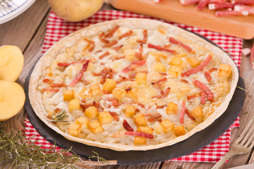 Tart with fried potato, raclette cheese and smoke flavour bacon.