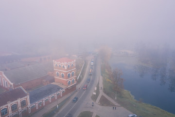 A view from the heights of the morning city in the fog. Tower of the old Paper mill landmark of the city of Dobrush, Belarus