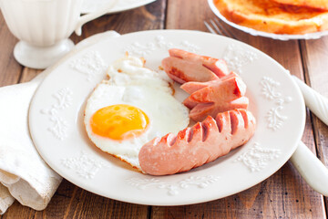 Fried sausages with fried eggs, selective focus