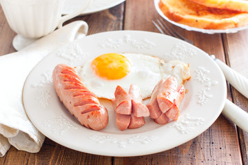 Fried sausages with fried eggs, selective focus