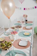 Food served on table in a white hall during a children Birthday party decoration in Eastern European Baltic Riga Latvia - Mild Biege, creme, pink colors - Canape, snacks and light drinks