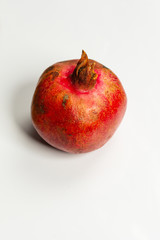 Very ripe pomegranate on white isolated background closeup.