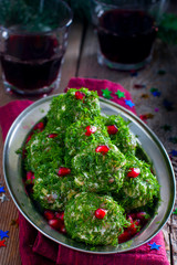 Festive appetizer in the form of balls of salted herring in fresh dill, selective focus
