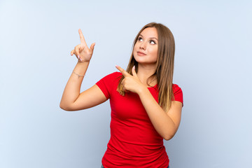 Teenager girl over isolated blue background pointing with the index finger a great idea