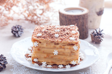 Homemade cake in Christmas decorations on a white plate, selective focus