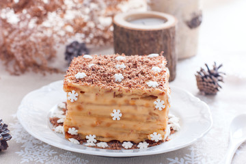 Homemade cake in Christmas decorations on a white plate, selective focus
