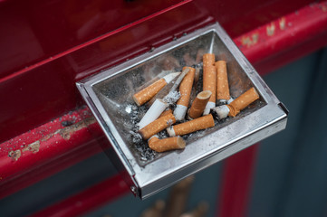 Closeup of pubic ashtray full of cigarettes in the street