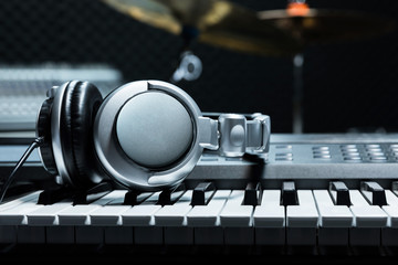 Fototapeta na wymiar Piano keyboard with headphones for music, Headphones on piano keyboard, close up,headphones on electric piano background by the music instruments background.