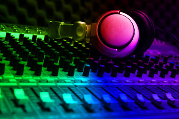 Fototapeta na wymiar Close-up of boutique recording studio control desk, dj headphones for professional disc, equipment for sound recording studio, mixer and DJ headphones