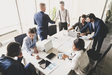 A team of young businessmen working and communicating together in an office. Corporate businessteam...