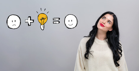 Good idea equals happy with happy young woman on a gray background