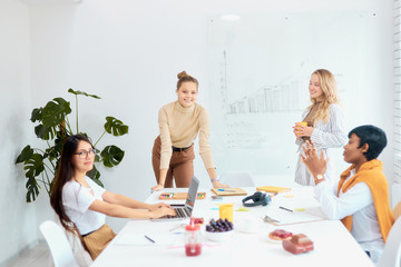 Time of brainstorm of multi-ethnic business team coworking in office, discuss new ideas in meeting office, using laptop