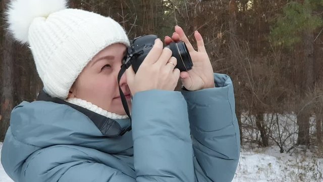 woman photographer takes pictures of nature in winter park