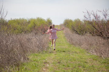 Beautiful blonde woman in pink dress on the road in the garden