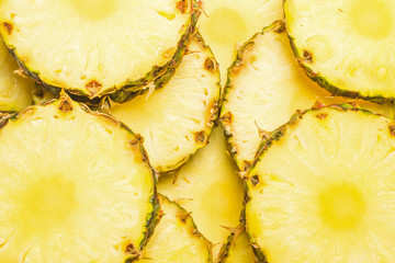 Pineapple juicy yellow slices background. Top view.