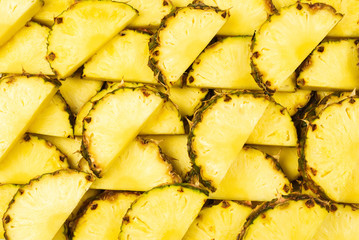 Pineapple juicy yellow slices background. Top view.