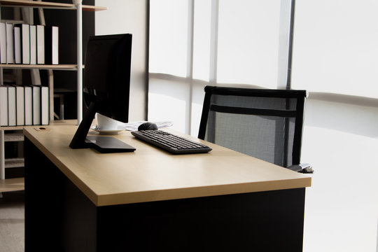 Modern personal computer, keyboard and cup of coffee on desktop in office workspace with window view. Concept of corporate job vacancy, financial world, manager and business.Vintage style