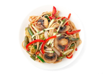 Wheat noodles with mushrooms, onions, green beans, paprika, broccoli, tiriyaki sauce, cucumber. On a white plate. View from above. White background. Isolate