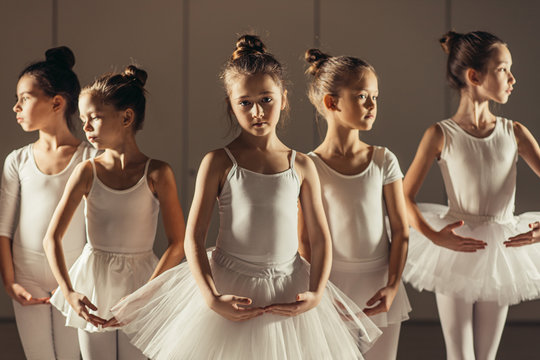 Group Of Caucasian Cute Girls 7-8 Years Old Dancing Classic Ballet Together Wearing White Tutu Skirts And Pointe Shoes