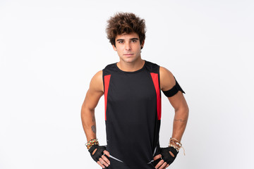 Young sport man with tattoos over isolated white background posing with arms at hip