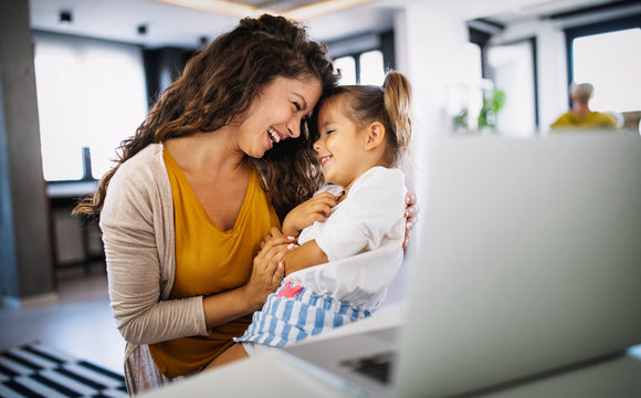 Mother at home trying to work with child distracting her