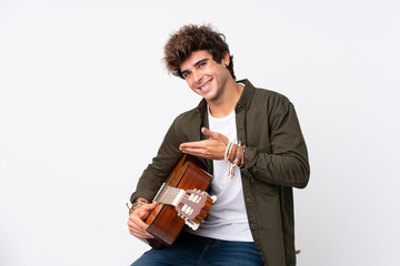 Young caucasian man with guitar over isolated white background extending hands to the side for inviting to come