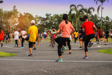 Back view of Group people workout exercise with dancing a fitness dance or aerobics in city park