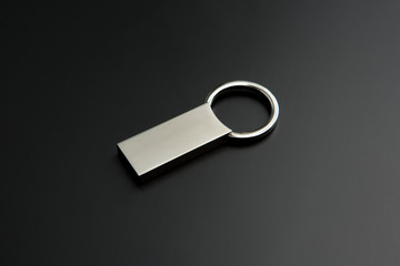 metallic squared key chain on black background
