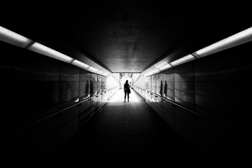 silhouette of a woman standing in a tunnel