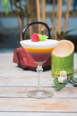 Tiramisu traditional dessert in a glass goblet on a wooden table.