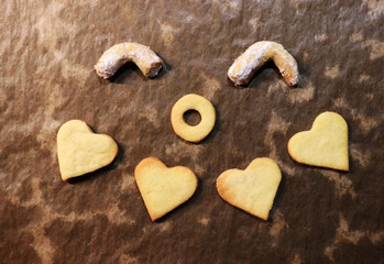 Happy smile created by gingerbread hearts and rolls on baking sheet. Winter holidays coming. Concept of smiling, happiness and teamwork