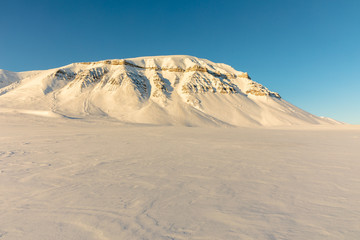 Fototapeta na wymiar Arctic winter landscape with snow covered mountains on Svalbard, Norway