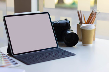 Work space on black table of photographer. Minimal workspace with Laptop, camera and lens copy space on dark background. Modern and elegant. Top view. Flat lay style. Close up.