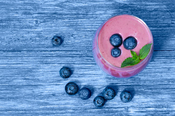 blueberry and blackberry smoothie on blue wooden background. milkshake with fresh berries. healthy fruit smoothie with ingredients. well being and weight loos concept. top view