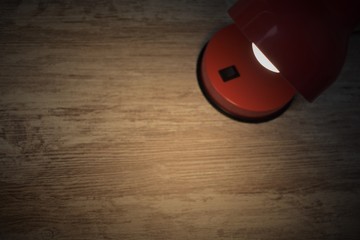 
Red lamp with white bulb illuminating part of a desk table