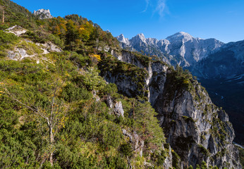 Sunny autumn alpine scene. Peaceful rocky mountain view from hiking path near Almsee lake, Upper Austria.