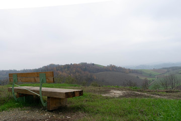 Lonely bench facing a natural landscape with hills