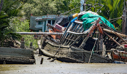 Fototapeta na wymiar The ship's ruin in the mud on the coast. The destroyed vessel lies in the bed of a dry river.