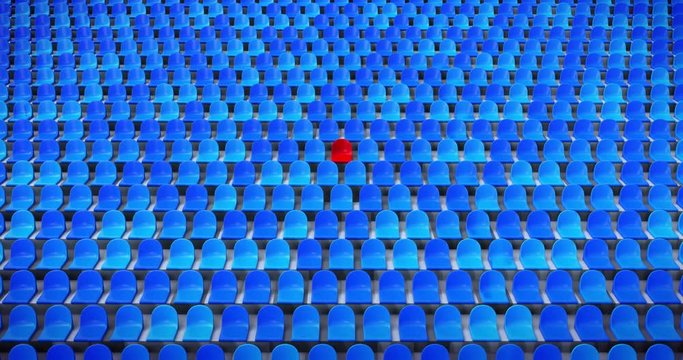 Zooming out from a unique red chair in the stadium