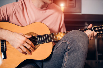 close-up of cropped male playing guitar indoors. Music, instruments concept