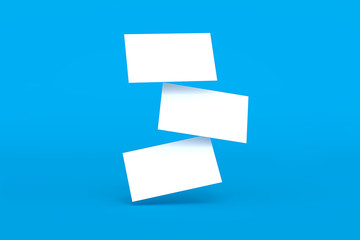 Falling blank white business cards on bright blue color background. 3D render illustration. Mockup design.