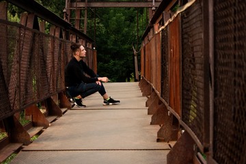 Young man on a bridge with a cigarette