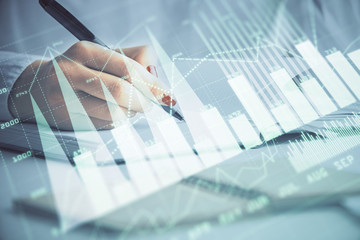 Multi exposure of woman's hands making notes with forex graph hologram. Concept stock market analysis.