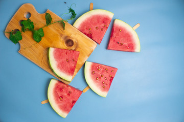 Fresh watermelon slices on sticks (seen from above).