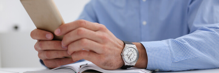 A businessman holds a new smartphone in his hand