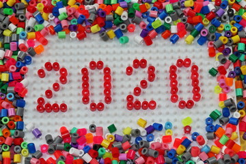 2020 written in red numbers with white background using Hama beads,